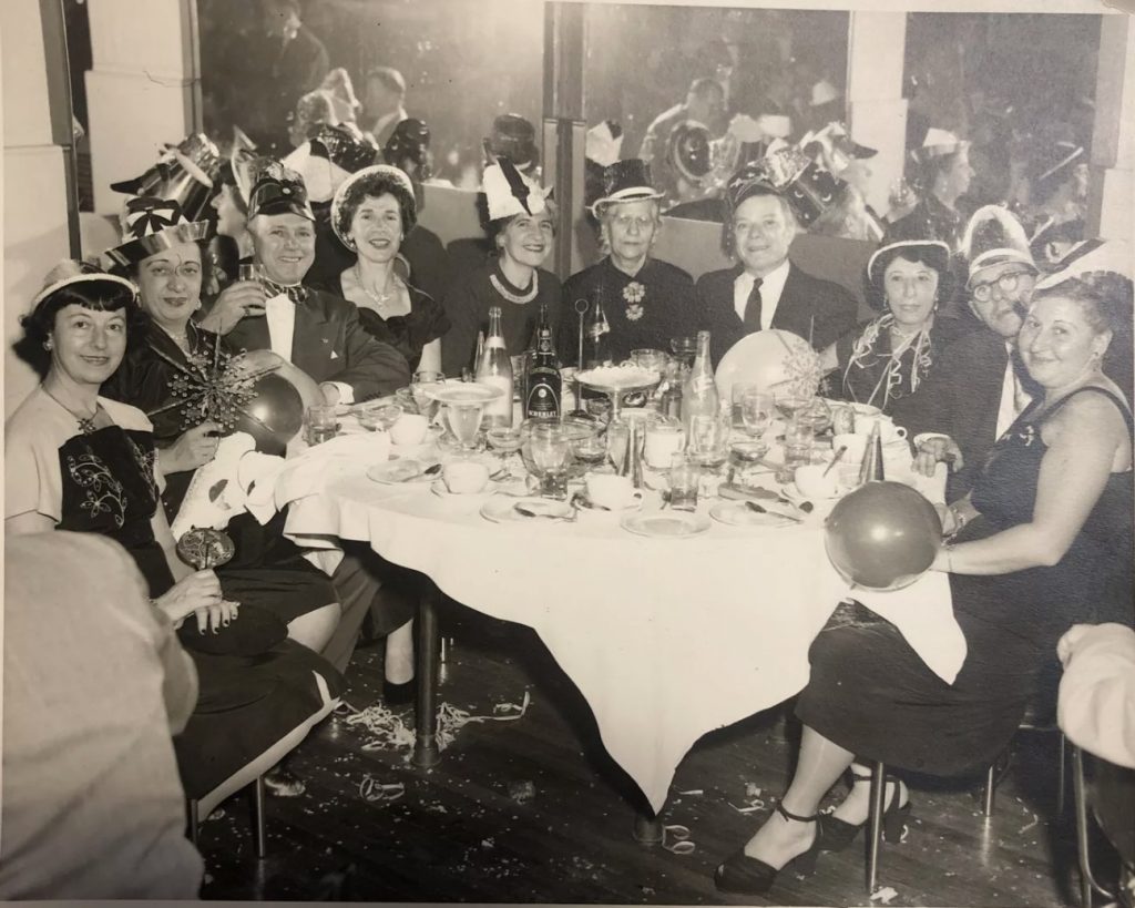 `1950s vintage Photo-Full table of people celebrating New Year's Eve together in the Bronx. Fantastic 1950s hairstyles & 1950s fashions. 