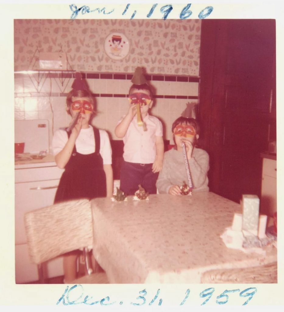 1960s vintage photo of kids celebrating New Years Eve. Dec 31st 1959 to Jan 1st, 1960. 