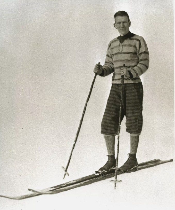 1920s vintage photo of a man in 1920s ski wear / 1920s ski fashions posing for a photo on his skis 